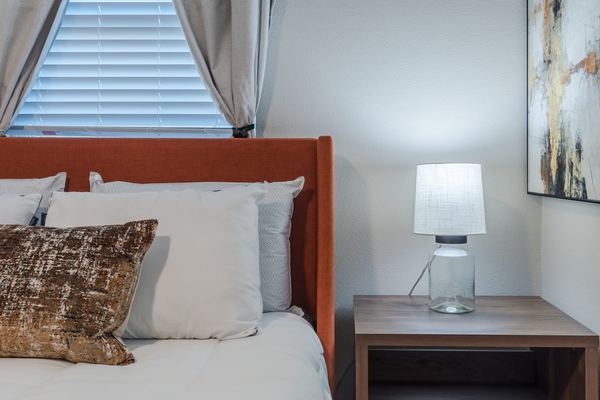 Bedroom detail with rust headboard and warm nightstand lamp