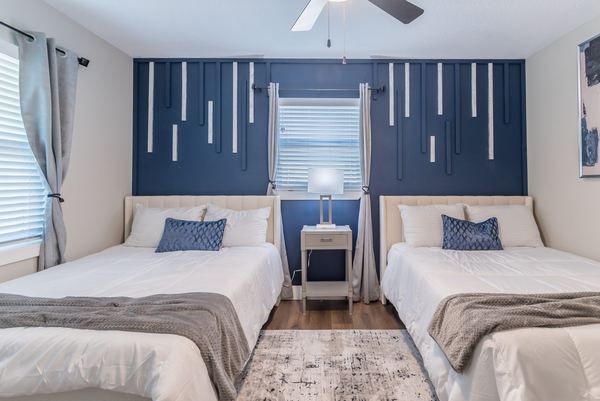 Guest room with two queen beds and bold navy accent wall