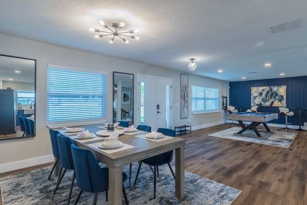 Dining room with 8-person table and navy upholstered chairs