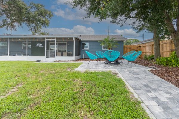 Back of house with neon sign and patio