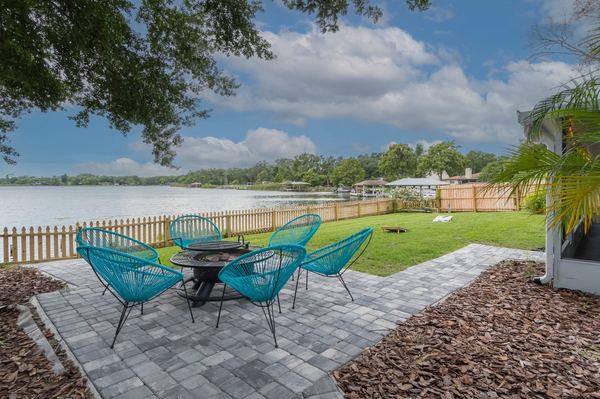 Lakefront patio with fire pit and teal chairs