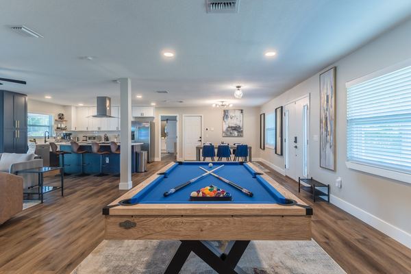 Open plan living and game room with pool table and kitchen