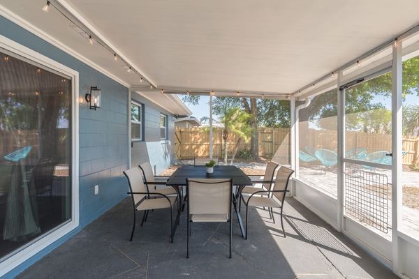 Screened porch with dining table and string lights